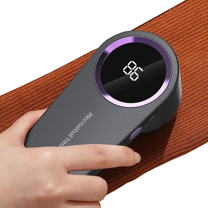 Electric lint remover in use, featuring a hand holding the device over a fabric surface for efficient lint removal.